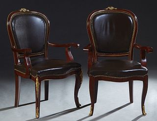 Pair of Ormolu Mounted Carved Mahogany Louis XV Style Armchairs, 20th c., the wide curved brown leather upholstered shield back with a bronze floral c