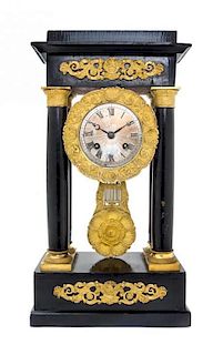 * An Empire Gilt Metal Mounted Ebonized Portico Clock Height 15 inches.