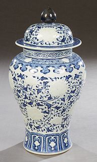 Large Oriental Porcelain Covered Ginger Jar, 20th c., of waisted form, with relief medallions and blue leaf decoration, the underside with an undergla