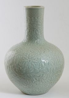 Chinese Celadon Porcelain Bottle Vase, 20th c., with relief floral and leaf decorated sides, the underside with a blue underglaze mark, H.- 13 1/4 in.