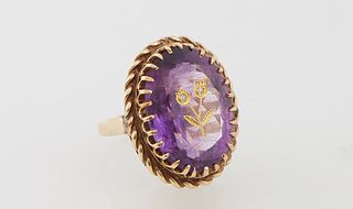18K Yellow Gold Dinner Ring, with an approx. 20 carat oval amethyst, with a gilt incised flower decoration on top, mounted with two diamond chips, abo