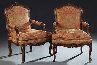 Pair of French Louis XV Style Carved Mahogany Fauteuils, 20th c., the arched canted floral carved back over upholstered arms, to a removable bowed cus