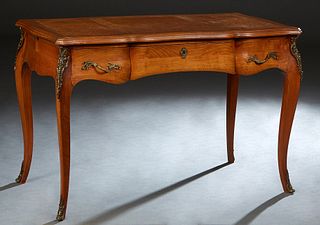 French Louis XV Style Ormolu Mounted Carved Cherry Writing Table, 20th c., the stepped serpentine top with an inset gilt tooled light brown leather wr