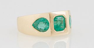 Lady's 18K Yellow Gold Dinner Ring, the wide band with an octagonal 6mm x 5mm emerald, flanked by two 9mm x 5mm pear shaped emeralds, on a tapering ba