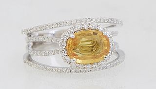 Lady's 18K White Gold Dinner Ring, with an oval 2.03 ct. yellow sapphire, atop four narrow pierced bands mounted with small round diamonds, total diam