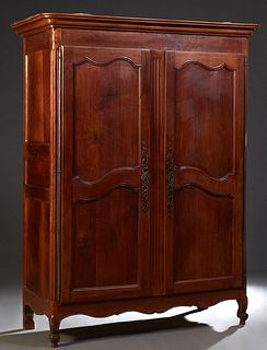 French Carved Cherry Louis XV Style Armoire, early 19th c., the stepped rounded corner crown over double two panel doors with long iron fiche hinges a