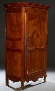 French Louis XV Style Carved Cherry Bonnetiere, 19th c., the stepped canted corner crown above a two panel door with a long iron escutcheon and fiche 