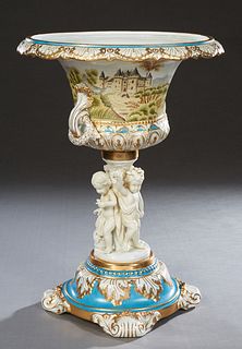 Sevres Style Porcelain Figural Centerpiece Bowl, 20th/21st c., the gilt decorated heavenly blue banded campana urn with landscape decorated sides on t