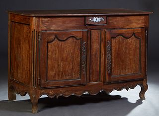 French Provincial Carved Walnut Sideboard, 19th c., the rounded corner top over a center frieze drawer above double cupboard doors with long iron escu