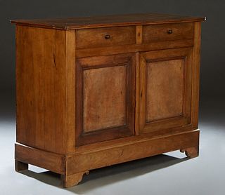 French Louis Philippe Carved Walnut Sideboard, 19th c., the two board top over two setback frieze drawers above double cupboard doors, on a plinth bas