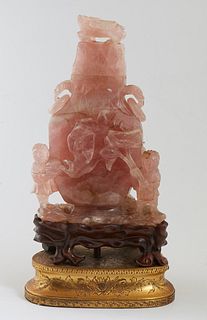 Chinese Carved Rose Quartz Covered Vase, early 20th c., the figural carved animal lid, over floral carved sides, with ring handles, on a carved mahoga