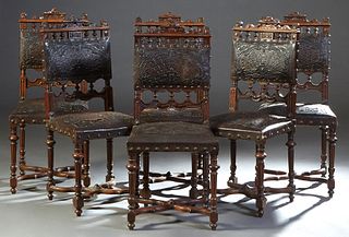 Set of Six Carved Oak Louis XIII Style Dining Chairs, 20th c., the arched crest rail over a spindled frieze and an embossed leather back above another