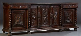 French Provincial Henri II Style Carved Oak Sideboard, c. 1880, the carved edge rectangular top over a central setback cupboard door with a high relie