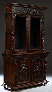 French Provincial Henri II Style Carved Oak Buffet a Deux Corps, c. 1880, with a stepped carved crown above a nut and leaf carved frieze over two roun