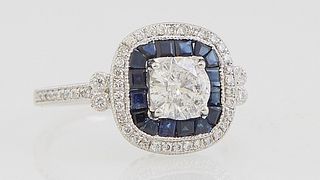 Lady's Platinum Dinner Ring, with a central .71 ct. round diamond atop a square border of princess cut sapphires within a border of tiny round diamond