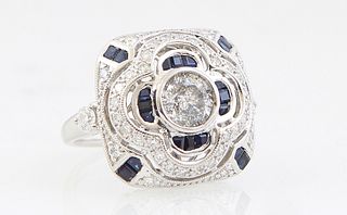 Lady's Platinum Dinner Ring, with a center 1.02 carat round diamond within a border of blue baguette sapphires, on a sloping square top mounted with t