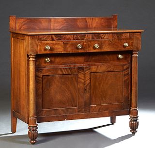 American Classical Carved Mahogany Sideboard, 19th c., with a stepped rectangular back splash over a rectangular top above two frieze drawers, over se