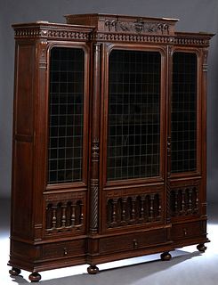 French Henri II Style Carved Walnut Bookcase, c. 1880, the stepped spindled crown over a central spindled door with a leaded stained glass upper panel