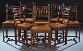 Set of Eight Henri II Style Carved Walnut Dining Chairs, late 19th c., the arched canted curved back with acorn finials, with a spindled horizontal sp