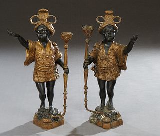 Pair of Gilt and Patinated Bronze Blackamoor Candlesticks, 20th c., on integral shaped stepped bases, H.- 16 in., W.- 8 1/2 in., D.- 5 in. Provenance: