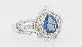 Lady's Platinum Dinner Ring, with a pear shaped 1.26 ct. blue sapphire, atop a conforming double graduated concentric border of round diamonds, over t