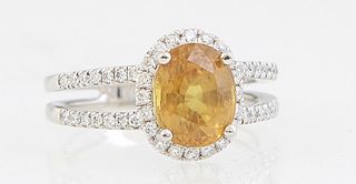 Lady's Platinum Dinner Ring, with a 3.28 ct. oval yellow sapphire atop a border of tiny round diamonds, on a pierced split shoulder band mounted with 