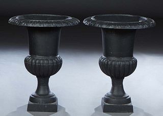 Pair of Cast Iron Campana Form Garden Urns, 20th/21st c., the relief everted rim over a relief waist, on an integral stepped square base, H.- 29 1/2 i