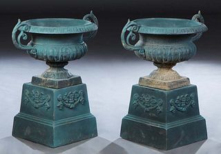 Pair of Green Cast Iron Planters, 20th/21st c., the campana form urn over pierced handled sides, on a socle support to a square base, on a stepped slo