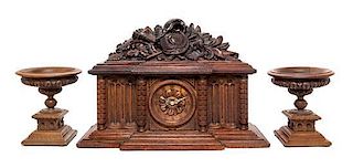 A Continental Carved Oak Three-Piece Clock Garniture Height of clock 15 1/2 inches.