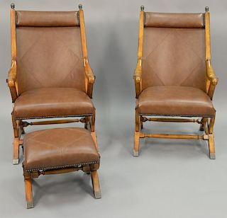 Pair of leather upholstered chairs with one footstool.