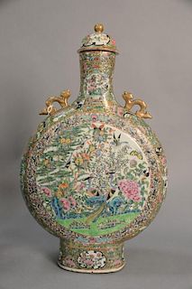 Large Famille porcelain moon flask having round neck flanked by two gilt dragons in relief above flattened circular body of garden s...