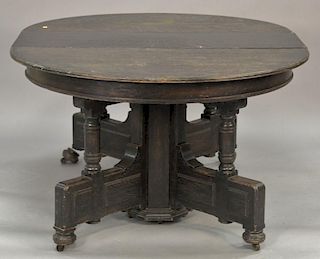Victorian round oak table with seven leaves, dark stained.