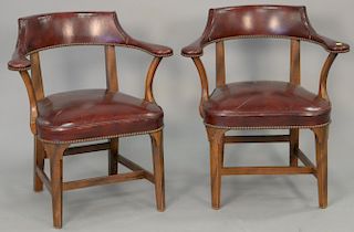 Pair of leather upholstered armchairs (surface cracks).