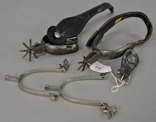 Pair of cast iron Western Cowboy spurs with silver inlay, leather straps with eight point star rowel.