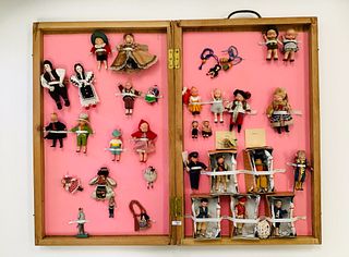 Lot of multiple small vintage dolls attached in a wooden case, closed case is approx 24" tall, 1" deep and 15" wide. Dolls range from being made of ya
