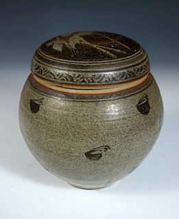 A studio pottery jar and cover, possibly by Andrew Hague, the stoneware body decorated in iron glaze