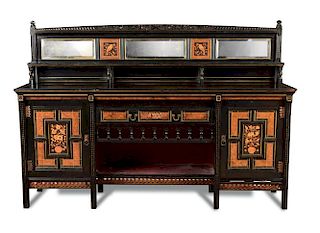An Aesthetic period ebonised sideboard, the mirrored superstructure with relief foliate carved top a