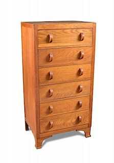 A Heal's style narrow oak chest of drawers, the six drawers each with crescent handles raised on sha