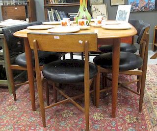 A mid 20th century teak dining table and eight G-Plan chairs, the table with draw leaf to either end