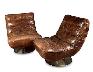 A pair of 20th century brown leather swivel easy chairs, the shaped seats raised on polished chrome
