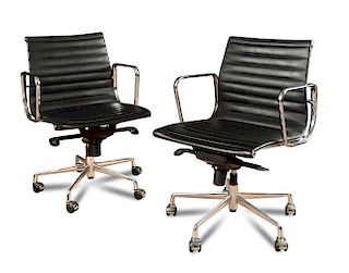 A pair of leather and alumnium swivel office chairs after the original design by Charles & Ray Eames