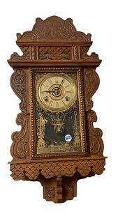 E. N. Welch 8-day clock with alarm. Measuring 28.5" long x 14.5" wide. Pendulum and key present but working condition unknown, with shelf.