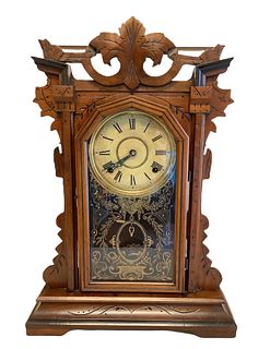 E. Ingraham 8-day clock. Measuring 21" high x 15" wide. Pendulum and key present but working condition unknown, with shelf.