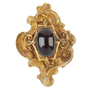 A late 19th century gold and garnet pendant. The oval cabochon garnet claw set to the wirework and s