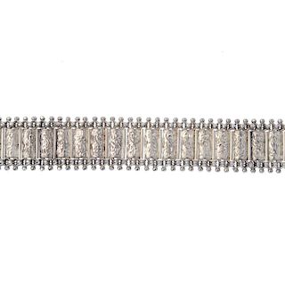 A late Victorian silver bracelet. Designed as a series of scroll engraved rectangular-shape links, w