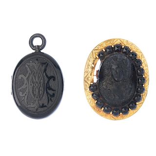 A late Victorian jet locket and a lava brooch. The locket of oval-outline, with engraved scrolling d