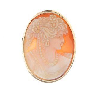 A shell cameo brooch depicting a woman in classical dress. The lady carved with flowers in her hair,