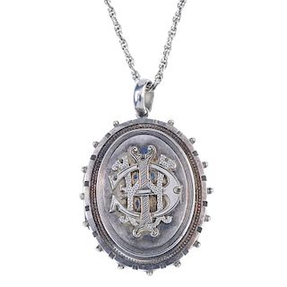 A late Victorian silver locket. The chain suspending a locket of oval outline, with castellated and