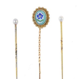 A set of three stickpins. To include a gold stickpin with oval-shape glass panel painted with a flow