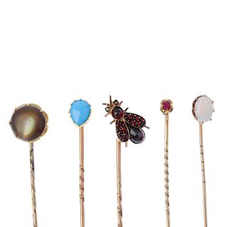 Five late 19th to early 20th century gem-set stickpins. To include a garnet and split pearl fly stic